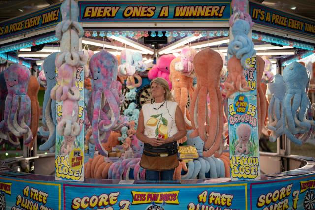 A stall holder waits for customers by their game at The Hoppings fun fair, believed to be one of the largest travelling funfairs in Europe, in Newcastle upon Tyne, north east England on June 20, 2026. The fun fair, which originally began as a Temperance Fair in 1882, comprises of over 400 attractions set up on the city's Town Moor. The fair runs until June 28, 2026 and is expected to attract around 500,000 people. (Photo by Oli SCARFF / AFP)