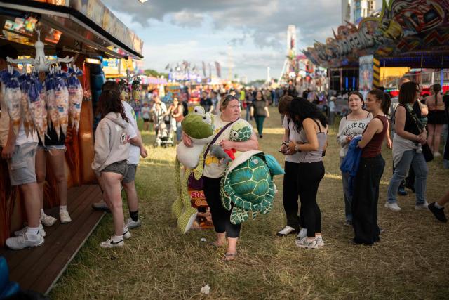 Members of the public queue for food as they attend The Hoppings fun fair, believed to be one of the largest travelling funfairs in Europe, in Newcastle upon Tyne, north east England on June 20, 2026. The fun fair, which originally began as a Temperance Fair in 1882, comprises of over 400 attractions set up on the city's Town Moor. The fair runs until June 28, 2026 and is expected to attract around 500,000 people. (Photo by Oli SCARFF / AFP)