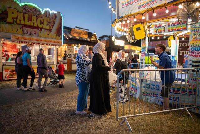 Members of the public attend The Hoppings fun fair, believed to be one of the largest travelling funfairs in Europe, in Newcastle upon Tyne, north east England on June 20, 2026. The fun fair, which originally began as a Temperance Fair in 1882, comprises of over 400 attractions set up on the city's Town Moor. The fair runs until June 28, 2026 and is expected to attract around 500,000 people. (Photo by Oli SCARFF / AFP)