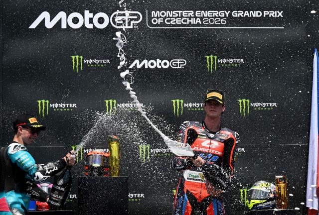 The winner Team MT Helmets - MSi's Ivan Ortola (R) and second placed Team CFMoto Aspar Racing Team's David Alonso (L) celebrate on the podium after the Moto2 event prior to the MotoGP Grand Prix of Czechia in Brno, Czech Republic, on June 21, 2026. (Photo by Michal Cizek / AFP)