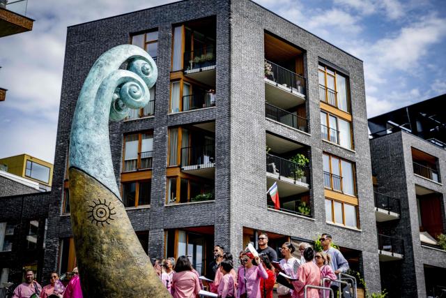 People wait ahead of the unveiling of a national monument at the Lloydkade for Moluccans during the commemoration of the Moluccan community that arrived there 75 years ago. In 1946, the first Moluccan men came to the Netherlands for training with the Royal Netherlands Navy, after which they served in active service in Amsterdam, as well as in Indonesia and other parts of the Kingdom. (Photo by Robin Utrecht / ANP / AFP) / Netherlands OUT
