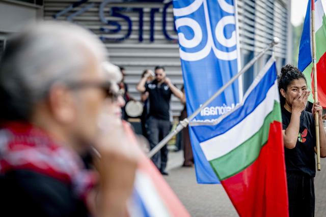 Demonstrators wait ahead of the unveiling of a national monument at the Lloydkade for Moluccans during the commemoration of the Moluccan community that arrived there 75 years ago. In 1946, the first Moluccan men came to the Netherlands for training with the Royal Netherlands Navy, after which they served in active service in Amsterdam, as well as in Indonesia and other parts of the Kingdom. (Photo by Robin Utrecht / ANP / AFP) / Netherlands OUT