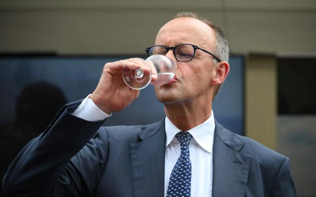 German Chancellor Friedrich Merz drinks some water as he visits soldiers of the German armed forces (Bundeswehr) during an event to mark the National Veterans' Day on June 21, 2026 in Berlin. The achievements of serving and former soldiers of the German armed forces (Bundeswehr) is honoured through events held across the country and a central celebration in Berlin. (Photo by RALF HIRSCHBERGER / AFP)