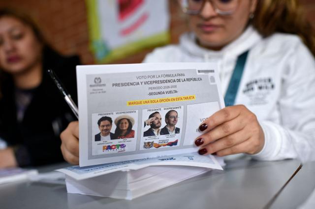 Workers prepare electoral material at a polling station before polls open for the presidential election runoff, in Bogota on June 21, 2026. Colombians head to the polls to pick a new president between a hard-right White House-backed lawyer and a leftist senator that will decide the fate of the country's stumbling peace process and strained ties with Washington. (Photo by Sebastian BARROS / AFP)