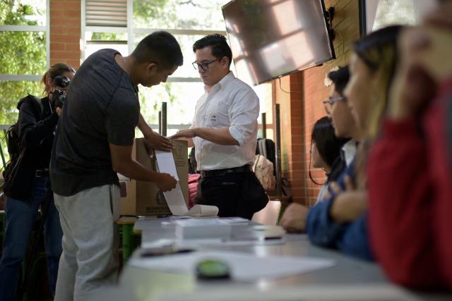 Workers prepare electoral material at a polling station before polls open for the presidential election runoff, in Bogota on June 21, 2026. Colombians head to the polls to pick a new president between a hard-right White House-backed lawyer and a leftist senator that will decide the fate of the country's stumbling peace process and strained ties with Washington. (Photo by Sebastian BARROS / AFP)