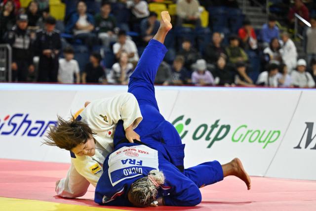Mao Arai of Japan (in white) and Romane Dicko of France (in blue) compete in the final of the women's +78kg category at the Judo Ulaanbaatar Grand Slam 2026 in Ulaanbaatar on June 21, 2026. (Photo by ADEK BERRY / AFP)