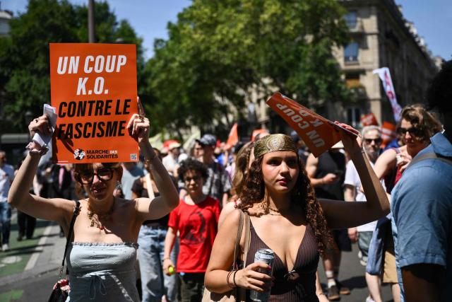 Protestors hold signs reading "A knowckout blow against facism" during a rally against racism and far-right in Paris on June 21, 2026. (Photo by Arnaud FINISTRE / AFP)