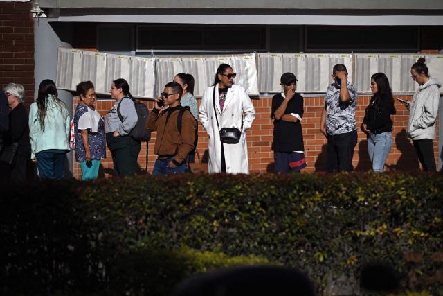 People queue to vote at a polling station just before the polls open for the presidential election runoff, in Bogota on June 21, 2026. Colombians head to the polls to pick a new president between a hard-right White House-backed lawyer and a leftist senator that will decide the fate of the country's stumbling peace process and strained ties with Washington. (Photo by Raul ARBOLEDA / AFP)
