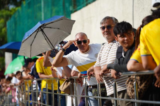 A supporter of Colombia's presidential candidate Abelardo de la Espriella salutes as people wait outside a polling center during the presidential election runoff in Barranquilla, Colombia, on June 21, 2026. Colombians head to the polls to pick a new president between a hard-right White House-backed lawyer and a leftist senator that will decide the fate of the country's stumbling peace process and strained ties with Washington. (Photo by Vanexa Romero / AFP)