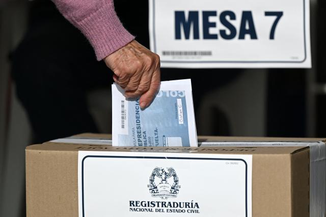 A woman casts her vote at a polling station during the presidential election runoff, in Bogota on June 21, 2026. Colombians head to the polls to pick a new president between a hard-right White House-backed lawyer and a leftist senator that will decide the fate of the country's stumbling peace process and strained ties with Washington. (Photo by Raul ARBOLEDA / AFP)