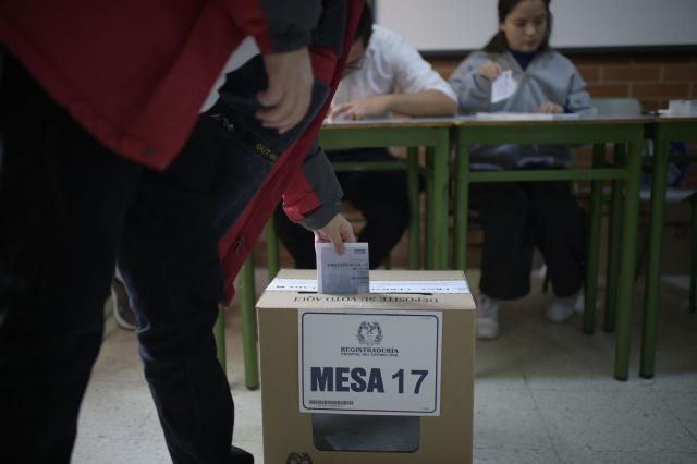 A person casts a vote at a polling station during the presidential election runoff, in Bogota on June 21, 2026. Colombians head to the polls to pick a new president between a hard-right White House-backed lawyer and a leftist senator that will decide the fate of the country's stumbling peace process and strained ties with Washington. (Photo by Sebastian BARROS / AFP)