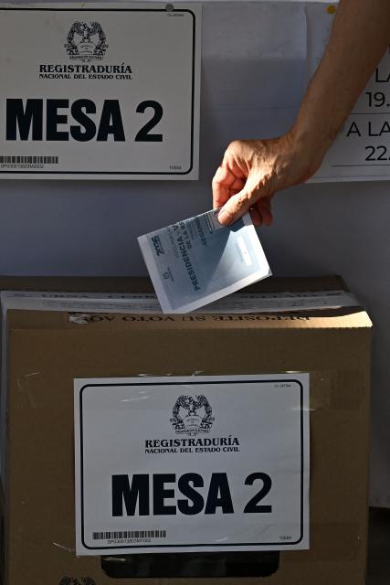 A man casts his vote during the presidential election runoff in Barranquilla, Colombia, on June 21, 2026. Colombians head to the polls to pick a new president between a hard-right White House-backed lawyer and a leftist senator that will decide the fate of the country's stumbling peace process and strained ties with Washington. (Photo by Juan BARRETO / AFP)