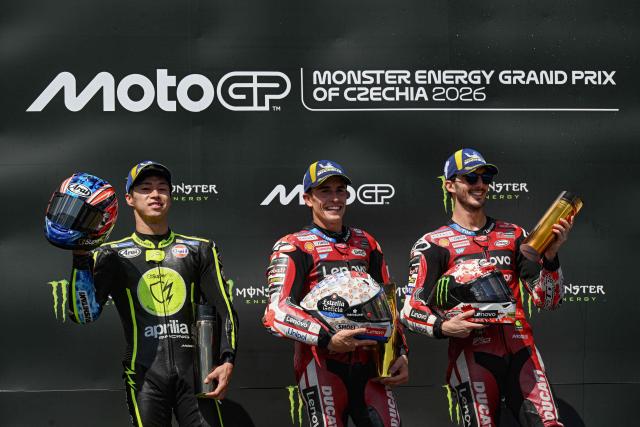 (L-R) Second placed Team Trackhouse Racing MotoGP's Ai Ogura, winner Team Ducati Lenovo Team's Marc Marquez and third placed Team Ducati Lenovo Team's Francesco Bagnaia react during the podium ceremony after the MotoGP Grand Prix of Czechia in Brno, Czech Republic, on June 21, 2026. (Photo by Michal Cizek / AFP)