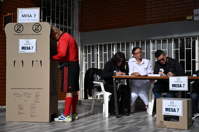 A man votes at a polling station during the presidential election runoff, in Bogota on June 21, 2026. Colombians head to the polls to pick a new president between a hard-right White House-backed lawyer and a leftist senator that will decide the fate of the country's stumbling peace process and strained ties with Washington. (Photo by Raul ARBOLEDA / AFP)