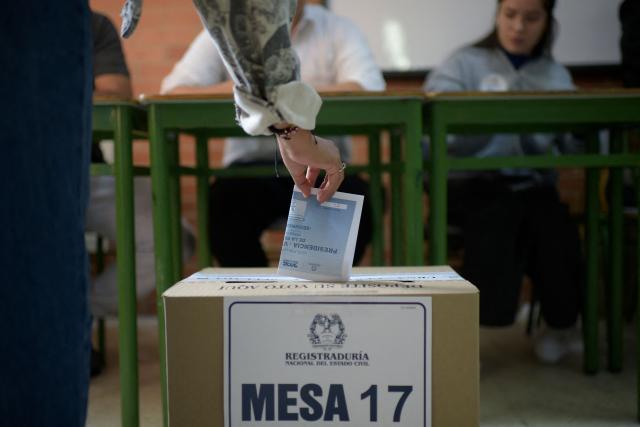 A woman casts her vote at a polling station during the presidential election runoff, in Bogota on June 21, 2026. Colombians head to the polls to pick a new president between a hard-right White House-backed lawyer and a leftist senator that will decide the fate of the country's stumbling peace process and strained ties with Washington. (Photo by Sebastian BARROS / AFP)