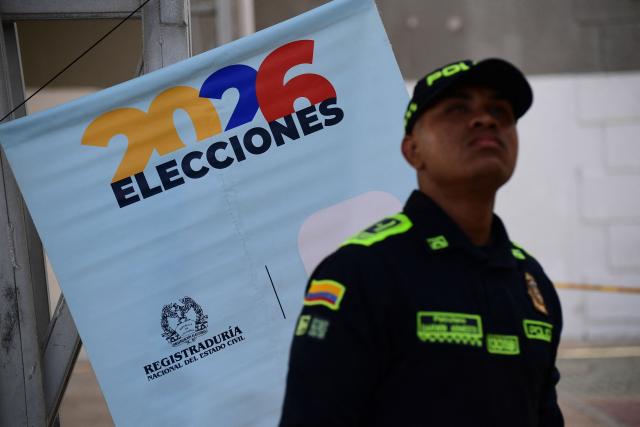A policeman stands guard at a polling center during the presidential election runoff in Barranquilla, Colombia, on June 21, 2026. Colombians head to the polls to pick a new president between a hard-right White House-backed lawyer and a leftist senator that will decide the fate of the country's stumbling peace process and strained ties with Washington. (Photo by Jaime SALDARRIAGA / AFP)