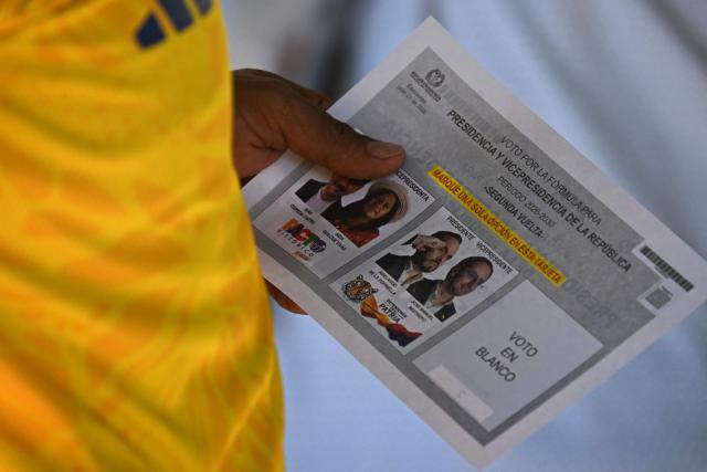 A man holds the ballot paper before voting during the presidential election runoff in Barranquilla, Colombia, on June 21, 2026. Colombians head to the polls to pick a new president between a hard-right White House-backed lawyer and a leftist senator that will decide the fate of the country's stumbling peace process and strained ties with Washington. (Photo by Juan BARRETO / AFP)