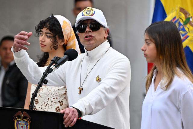 Colombia's President Gustavo Petro speaks next to his daughters Sofia (L) and Antonella at a polling station during the presidential election runoff, in Bogota on June 21, 2026. Colombians head to the polls to pick a new president between a hard-right White House-backed lawyer and a leftist senator that will decide the fate of the country's stumbling peace process and strained ties with Washington. (Photo by Luis ACOSTA / AFP)