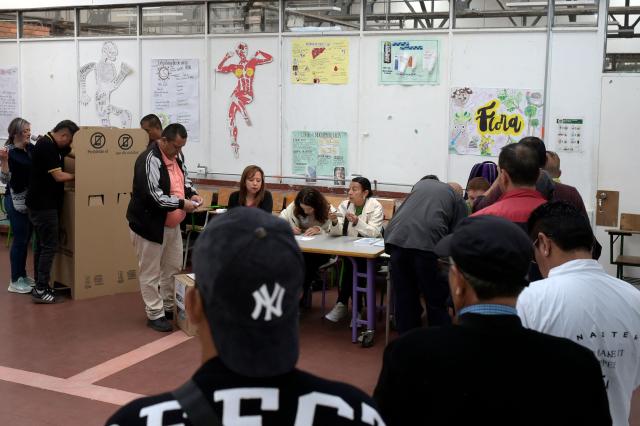 People queue to vote at a polling station during the presidential election runoff, in Bogota on June 21, 2026. Colombians head to the polls to pick a new president between a hard-right White House-backed lawyer and a leftist senator that will decide the fate of the country's stumbling peace process and strained ties with Washington. (Photo by Sebastian BARROS / AFP)