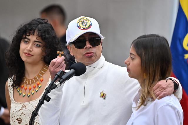 Colombia's President Gustavo Petro shows a cross as he speaks next to his daughters Sofia (L) and Antonella at a polling station during the presidential election runoff, in Bogota on June 21, 2026. Colombians head to the polls to pick a new president between a hard-right White House-backed lawyer and a leftist senator that will decide the fate of the country's stumbling peace process and strained ties with Washington. (Photo by Luis ACOSTA / AFP)