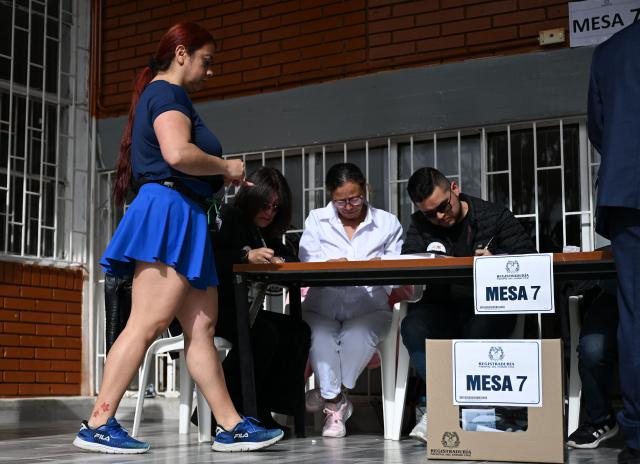 A woman prepares to vote at a polling station during the presidential election runoff, in Bogota on June 21, 2026. Colombians head to the polls to pick a new president between a hard-right White House-backed lawyer and a leftist senator that will decide the fate of the country's stumbling peace process and strained ties with Washington. (Photo by Raul ARBOLEDA / AFP)