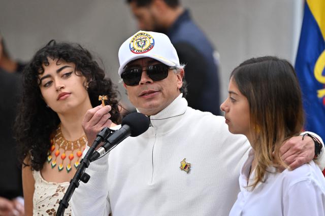 Colombia's President Gustavo Petro shows a Taw (last letter of the Aramaic alphabet) as he speaks next to his daughters Sofia (L) and Antonella at a polling station during the presidential election runoff, in Bogota on June 21, 2026. Colombians head to the polls to pick a new president between a hard-right White House-backed lawyer and a leftist senator that will decide the fate of the country's stumbling peace process and strained ties with Washington. (Photo by Luis ACOSTA / AFP)