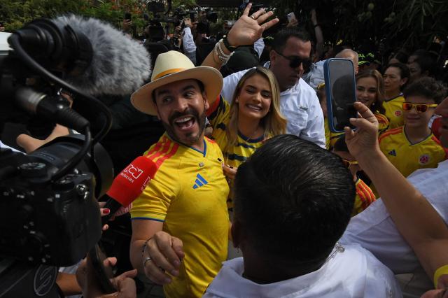 Colombia's presidential candidate for the Defensores de la Patria movement, Abelardo de la Espriella, gestures as he leaves a polling station next to his wife Ana Lucia Pineda, during the presidential election runoff in Barranquilla, Colombia, on June 21, 2026. Colombians head to the polls to pick a new president between a hard-right White House-backed lawyer and a leftist senator that will decide the fate of the country's stumbling peace process and strained ties with Washington. (Photo by Jaime SALDARRIAGA / AFP)