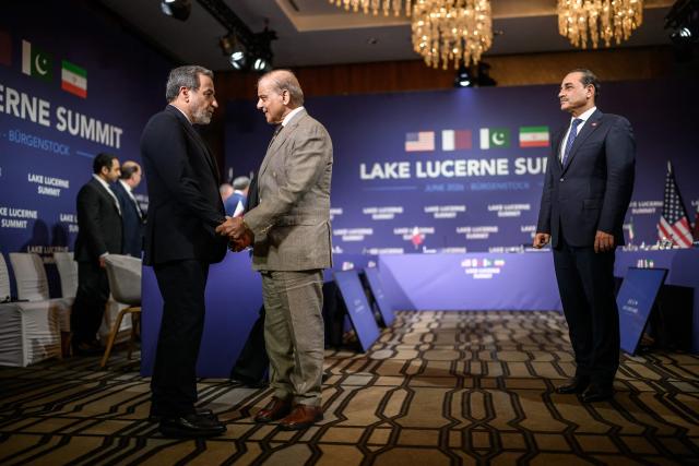Iran's Foreign Minister Abbas Araghchi (L) shakes hands with Pakistan's Prime Minister Muhammad Shehbaz Sharif (C) next to Pakistan's Chief of Army Staff Field Marshal Asim Munir (R) prior to a quadrilateral meeting between the United States, Iran, Pakistan and Qatar at the Burgenstock luxury hotel complex overlooking Lake Lucerne, Switzerland, on June 21, 2026, as part of high-level talks aimed at advancing a deal to end the Middle East conflict. A new round of negotiations over the Middle East war was set to kick off on June 21, 2026 with Iranian negotiators arriving in the Swiss host city hours ahead of US Vice President JD Vance, even as Tehran said it was closing the Strait of Hormuz again over Israeli attacks in Lebanon. (Photo by Fabrice COFFRINI / POOL / AFP)
