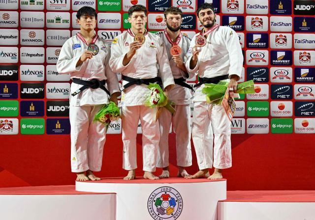 Gold medallist Sanshiro Murao of Japan (2L), silver medallist Kim Jong-hoon of South Korea (L), bronze medallists Boris Rutovic of Serbia (2R) and Murad Fatiyev of Azerbaijan pose for photographs during the medal ceremony for the men's under 90kg category at the Judo Ulaanbaatar Grand Slam 2026 in Ulaanbaatar on June 21, 2026. (Photo by ADEK BERRY / AFP)