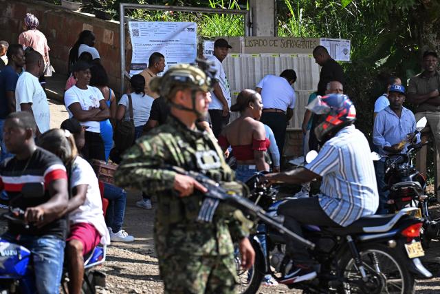 A soldier stands guard outside a polling station during the presidential election runoff, in Quinamayo, municipality of Santander de Quilichao, Valle del Cauca, Colombia, on June 21, 2026. Colombians head to the polls to pick a new president between a hard-right White House-backed lawyer and a leftist senator that will decide the fate of the country's stumbling peace process and strained ties with Washington. (Photo by Joaquin SARMIENTO / AFP)