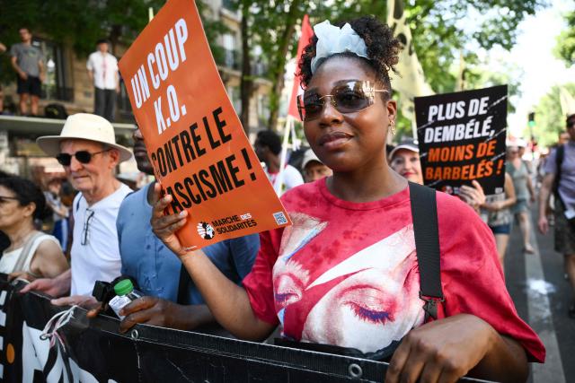 A protestor holds a sign reading "A knowckout blow against facism" during a rally against racism and far-right in Paris on June 21, 2026. (Photo by Arnaud FINISTRE / AFP)
