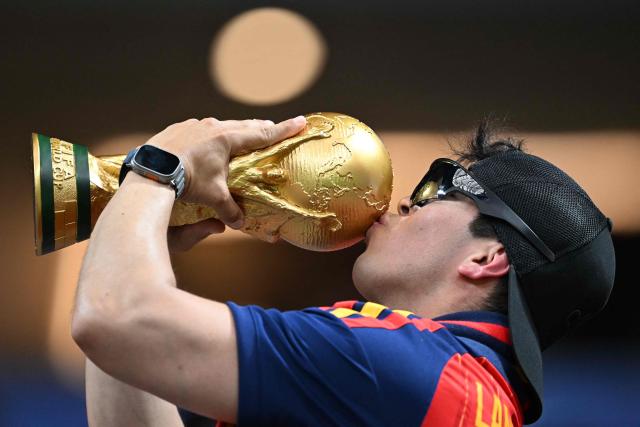 A Spain supporter kisses a model of the competition trophy prior to the  2026 World Cup Group H football match between Spain and Saudi Arabia at the Atlanta Stadium in Atlanta on June 21, 2026.  (Photo by ROBERTO SCHMIDT / AFP)