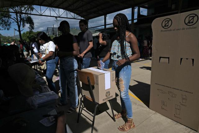 A woman votes at a polling station during the presidential election runoff, in Santander de Quilichao, Cauca, Colombia, on June 21, 2026. Colombians head to the polls to pick a new president between a hard-right White House-backed lawyer and a leftist senator that will decide the fate of the country's stumbling peace process and strained ties with Washington. (Photo by JOAQUIN SARMIENTO / AFP)
