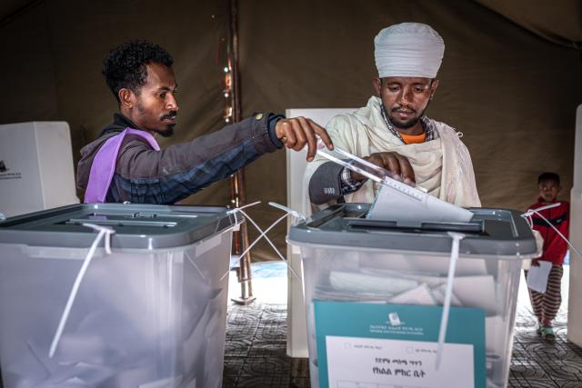 (FILES) A voter casts his ballot assisted by a National Election Board of Ethiopia (NEBE) official at Beshale Katla polling station in Addis Ababa, on June 1, 2026, during the 2026 Ethiopian parliamentary elections. Ethiopian Prime Minister Abiy Ahmed's Prosperity Party (PP) won a landslide victory in legislative polls held June 1, the election commission said Sunday, giving it almost 90 percent of the seats.
Abiy has led Ethiopia since 2018, and is increasingly criticised for growing authoritarianism, in contrast to his early years when he won the Nobel Peace Prize for mending relations with neighbouring Eritrea.
The PP was considered the overwhelming favourite in the country of 130 million, facing a divided opposition that did not field candidates in many constituencies. (Photo by Marco Simoncelli / AFP)