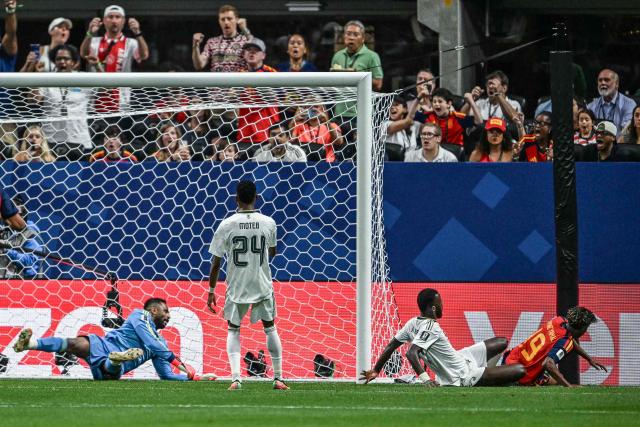 Spain's forward #19 Lamine Yamal (R) reacts as he scores the opening goal past Saudi Arabia's goalkeeper #21 Mohammed Al-Owais (L)  during the 2026 World Cup Group H football match between Spain and Saudi Arabia at the Atlanta Stadium in Atlanta on June 21, 2026.  (Photo by ROBERTO SCHMIDT / AFP)