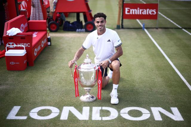Argentina's Francisco Cerundolo poses for photographers with the winners trophy after his victory over US player Tommy Paul during the men's singles final tennis match on day six of the ATP HSBC Championships at Queen's Club in west London on June 21, 2026. (Photo by Henry NICHOLLS / AFP)