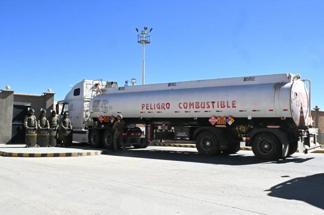 Bolivian soldiers stand guard as tank trucks enter the state-owned Yacimientos Petrolíferos Fiscales Bolivianos (YPFB) Senkata plant, in El Alto, Bolivia, on June 21, 2026, a day after Bolivia's President Rodrigo Paz declared a state of emergency. Bolivian police driving bulldozers cleared highways and fuel trucks rolled into La Paz after the president declared a state of emergency to remove anti-government roadblocks promoted by unions, Indigenous groups, and coca growers that had paralyzed the Andean nation for more than six weeks. (Photo by AIZAR RALDES / AFP)