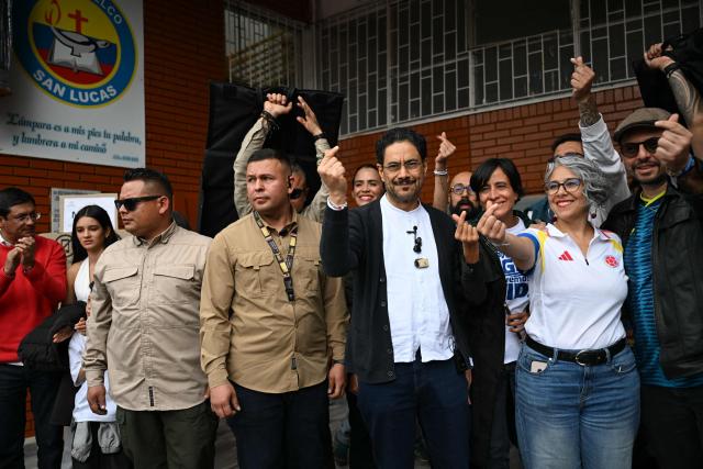 Colombia's presidential candidate for the ruling Pacto Historico party, Ivan Cepeda (3-R), gestures at a polling station next to Senator Maria Jose Pizarro (2-R) during the presidential election runoff, in Bogota on June 21, 2026. Colombians head to the polls to pick a new president between a hard-right White House-backed lawyer and a leftist senator that will decide the fate of the country's stumbling peace process and strained ties with Washington. (Photo by Raul ARBOLEDA / AFP)