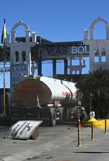 Tank trucks cross a toll in the road linking Desaguaderos-La Paz, in Laja, Bolivia, on June 21, 2026, a day after Bolivia's President Rodrigo Paz declared a state of emergency. Bolivian police driving bulldozers cleared highways and fuel trucks rolled into La Paz after the president declared a state of emergency to remove anti-government roadblocks promoted by unions, Indigenous groups, and coca growers that had paralyzed the Andean nation for more than six weeks. (Photo by AIZAR RALDES / AFP)