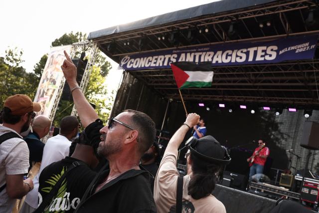A member of the French band Karl Marx and the Space Ninjas waves the Palestiian flag as he performs during a concert organised by French left-wing La France Insoumise (LFI) party as part of the annual street music festival 'Fete de la Musique' in Paris on June 21, 2026. (Photo by Guillaume BAPTISTE / AFP)