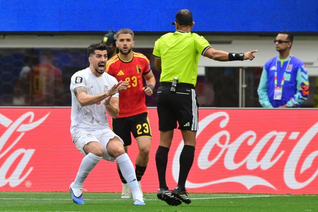Iran's midfielder #06 Saeid Ezatolahi argues with Argentine referee Dario Herrera during the 2026 World Cup Group G football match between Belgium and Iran at the Los Angeles Stadium in Inglewood on June 21, 2026.  (Photo by Frederic J. Brown / AFP)