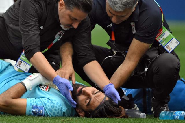 Iran's goalkeeper #01 Alireza Beiranvand receives medical attention during the 2026 World Cup Group G football match between Belgium and Iran at the Los Angeles Stadium in Inglewood on June 21, 2026.  (Photo by Patrick T. Fallon / AFP)