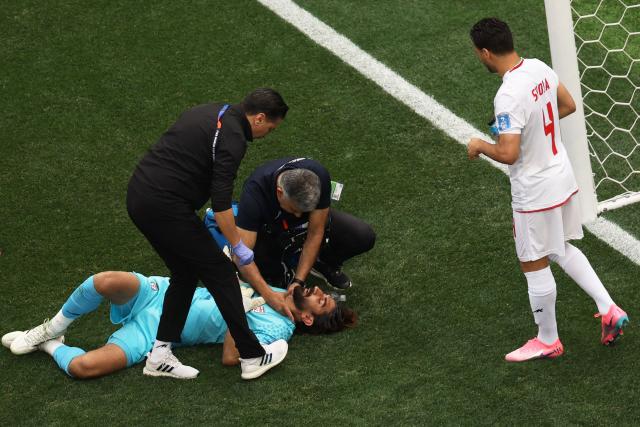Iran's goalkeeper #01 Alireza Beiranvand receives medical attention during the 2026 World Cup Group G football match between Belgium and Iran at the Los Angeles Stadium in Inglewood on June 21, 2026.  (Photo by Etienne Laurent / AFP)
