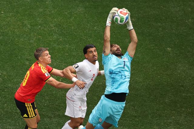 Iran's midfielder #07 Alireza Jahanbakhsh makes a save next to Belgium's forward #10 Leandro Trossard and Iran's defender #02 Saleh Hardani during the 2026 World Cup Group G football match between Belgium and Iran at the Los Angeles Stadium in Inglewood on June 21, 2026.  (Photo by Etienne Laurent / AFP)
