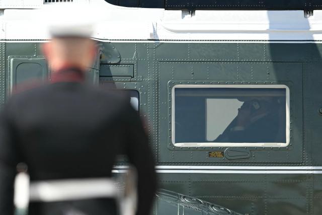 US President Donald Trump is seen on his phone as he arrives aboard Marine One at Joint Base Andrews, Maryland on June 21, 2026. Trump is returning to the White House from Camp David. (Photo by Kent NISHIMURA / AFP)