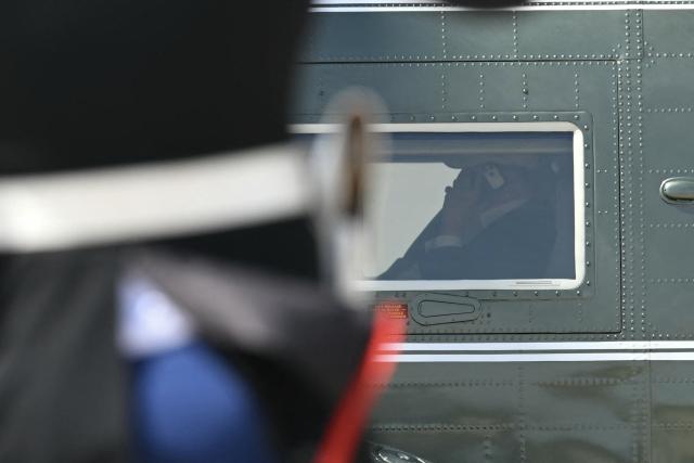 US President Donald Trump is seen on his phone as he arrives aboard Marine One at Joint Base Andrews, Maryland on June 21, 2026. Trump is returning to the White House from Camp David. (Photo by Kent NISHIMURA / AFP)
