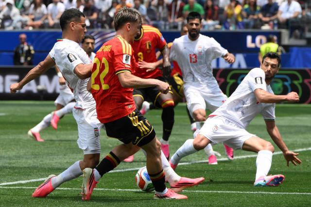 Iran's defender #19 Ali Nemati, Belgium's forward #22 Alexis Saelemaekers and Iran's defender #04 Shojae Khalilzadeh fight for the ball during the 2026 World Cup Group G football match between Belgium and Iran at the Los Angeles Stadium in Inglewood on June 21, 2026.  (Photo by Patrick T. Fallon / AFP)