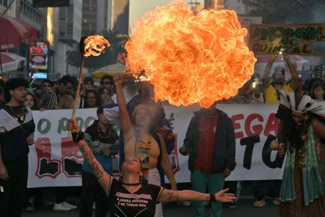 A performer breathes fire during a demonstration calling for the legalization of marijuana on Paulista Avenue in Sao Paulo, Brazil, on June 21, 2026. (Photo by NELSON ALMEIDA / AFP)
