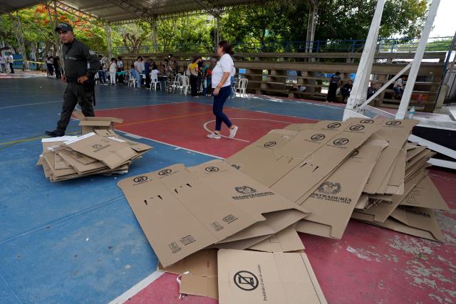 A police officer walks past unused voting materials during the presidential election runoff in Barranquilla, Colombia, on June 21, 2026. Colombians voted on June 21 in a polarized presidential runoff that could reshape the country's fragile peace process and relations with the United States, after the most violent election campaign in a decade. (Photo by Vanexa Romero / AFP)