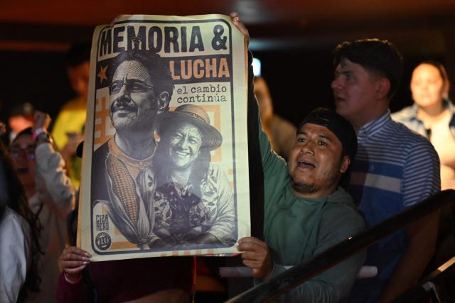 Supporters of Colombia's presidential candidate for the ruling Pacto Historico party Ivan Cepeda hold a poster featuring Cepeda and running mate Aida Quilcue reading "Memory and Struggle, change continues" as they wait for the results of the presidential runoff election at the Tequendama Hotel in Bogota on June 21, 2026. Colombians voted on June 21 in a polarized presidential runoff that could reshape the country's fragile peace process and relations with the United States, after the most violent election campaign in a decade. (Photo by Raul ARBOLEDA / AFP)